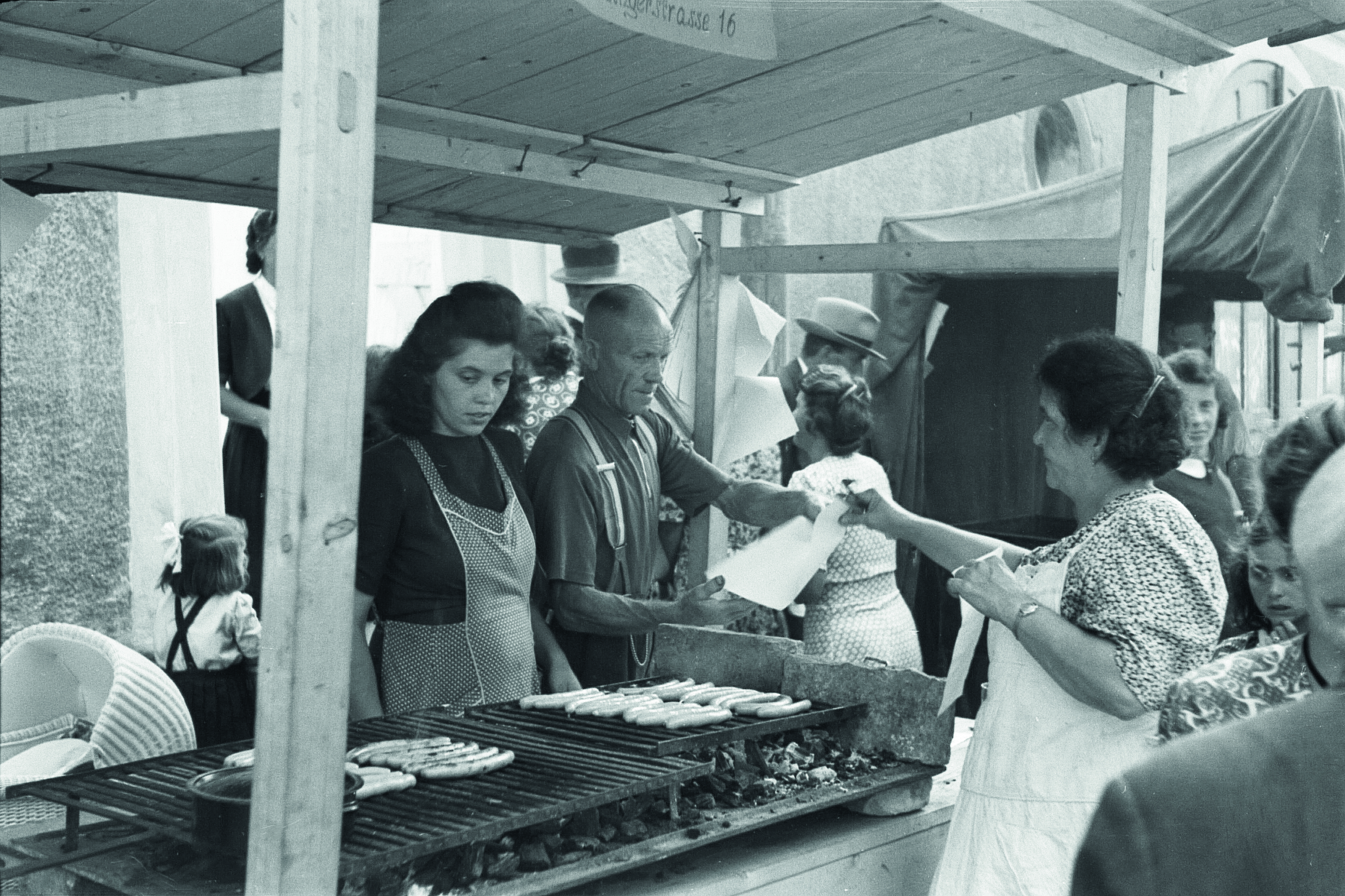 Die heutige typische &quot;Mess-Wurst&quot; taucht erstmals in den 1920er Jahren auf. Das Bild zeigt einen Würstl-Stand von 1950