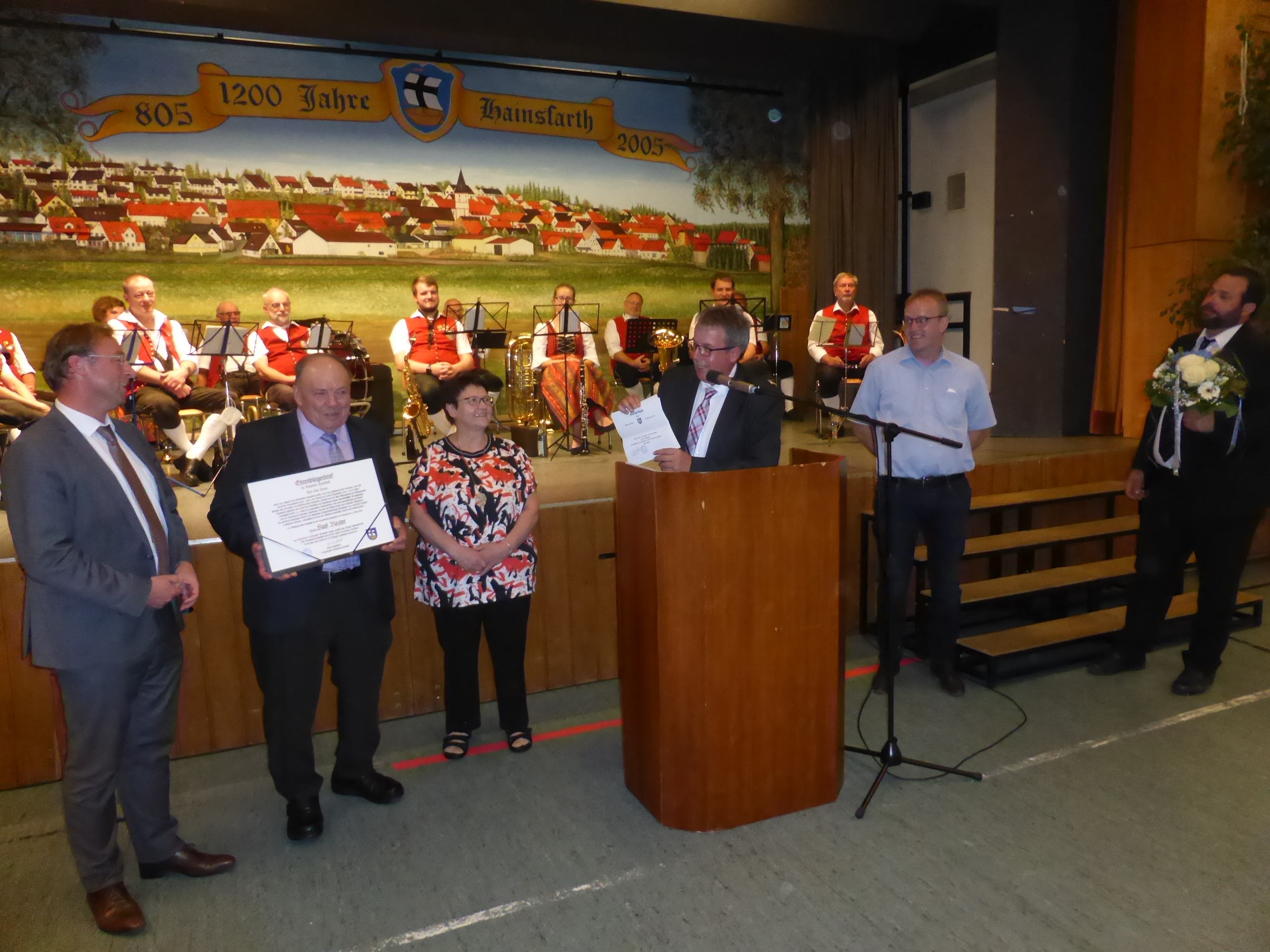 MdL Wolfgang Fackler, 1. Bgm. Klaus Engelhardt, 2. Bgm. Herbert Seefried und 3. Bgm. Johannes Meyer überreichen Herrn Karl Reuter im Beisein seiner Ehefrau Rita Reuter den Ehrenbürger-Brief der Gemeinde Hainsfarth.