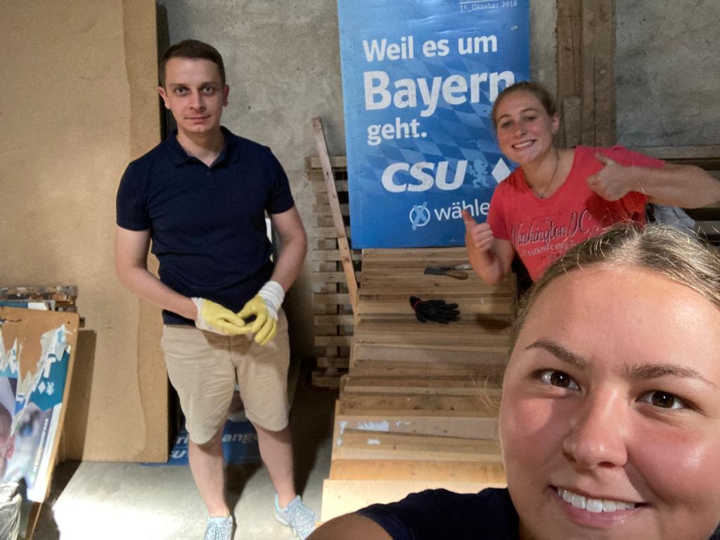 Mann und zwei Frauen vor CSU-Wahlplakat