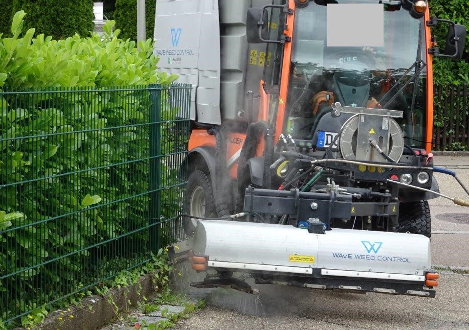 Straßenreinigungsmaschine bekämpft Unkraut mit Heißwasser