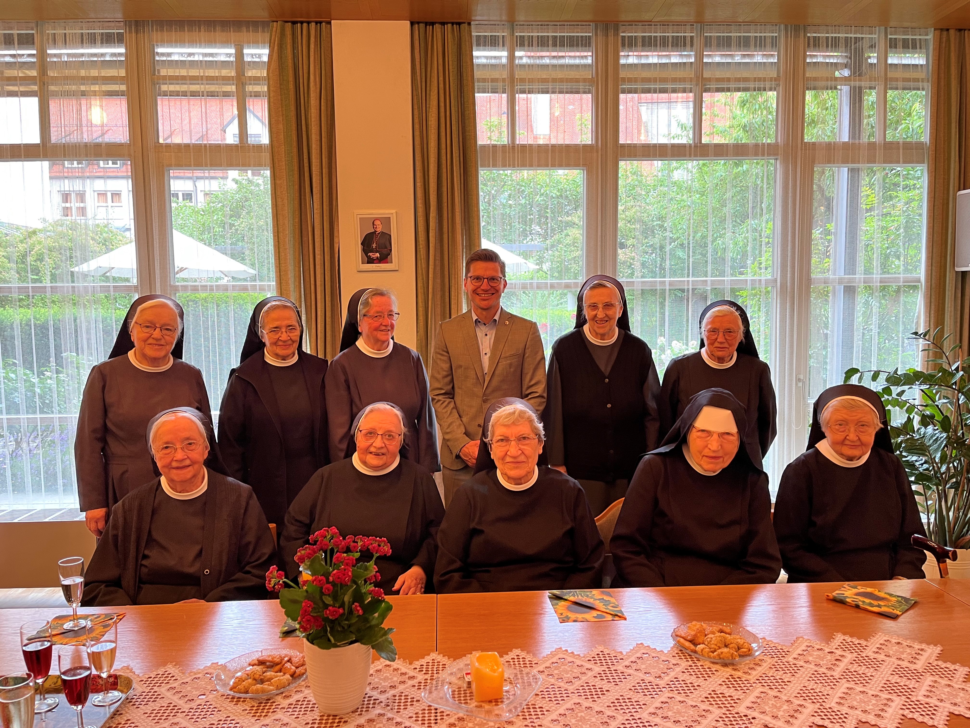 Oberbürgermeister David Wittner gratuliert Sr. Adelhilde (beide Mitte hinten) zum runden Geburtstag.