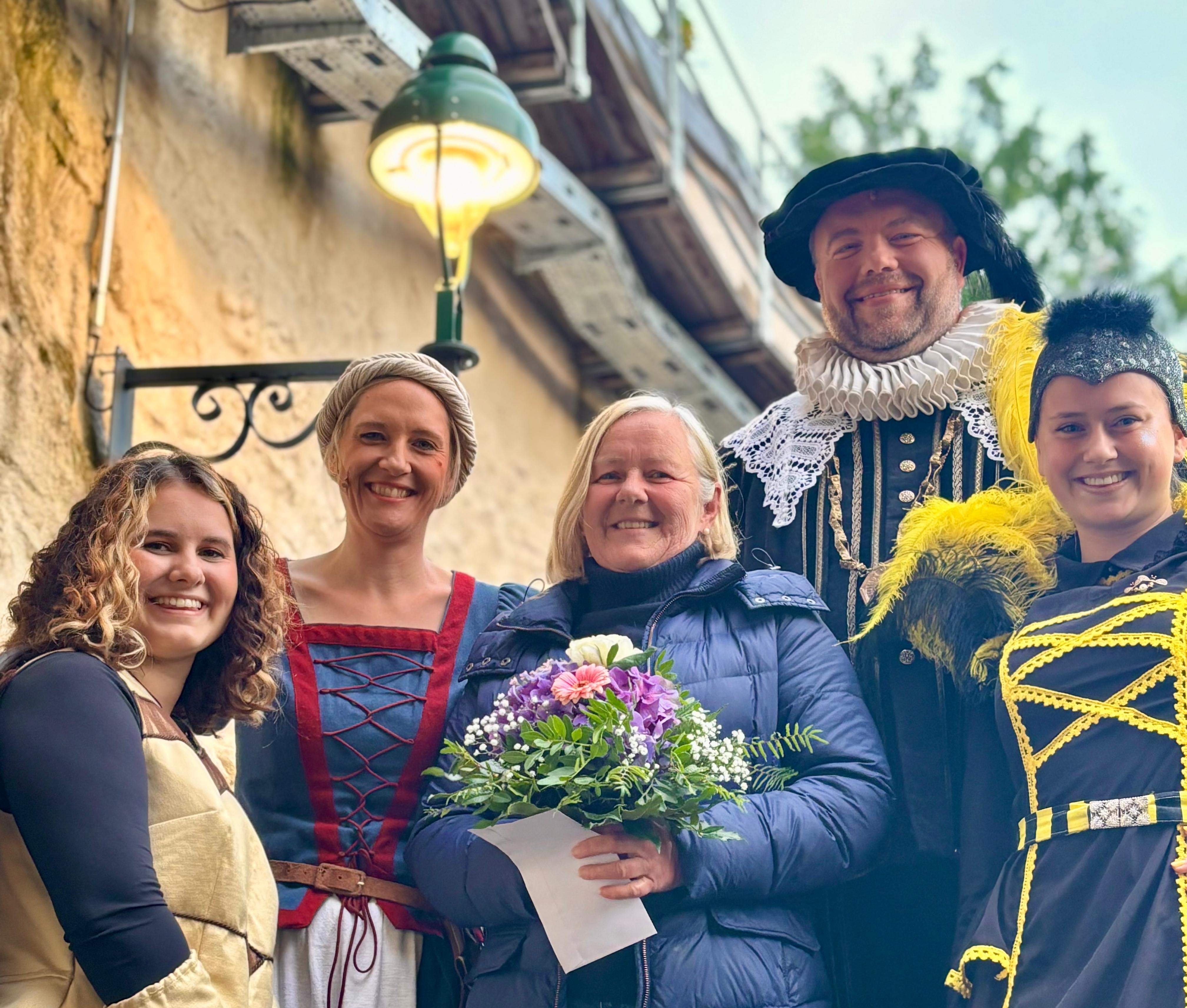 Die 15.950. Besucherin der Spielzeit, Frau Karin Bauer, wurde auf der Freilichtbühne „Alte Bastei“ von Darstellerinnen und Darstellern aus den Produktionen Maria Holl – Hexenjagd in Nördlingen und Tabaluga – Es lebe die Freundschaft begrüßt. Mit dabei: Nina Hellriegel (Maria Holl), Alexander Güntert (Bürgermeister Pferinger), Theresa Stroszeck (Nessaja), sowie Ninivee Weichenmeier (Bienenkönigin).
