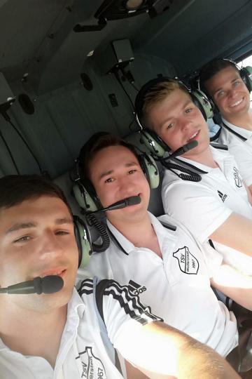 Das Bild zeigt die vier Spieler im Hubschrauber.