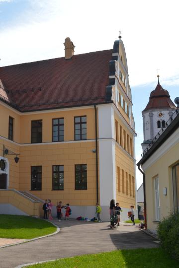 Auf dem Bild zu sehen die Grundschule Buchdorf neben der Pfarrkirche St. Ulrich.