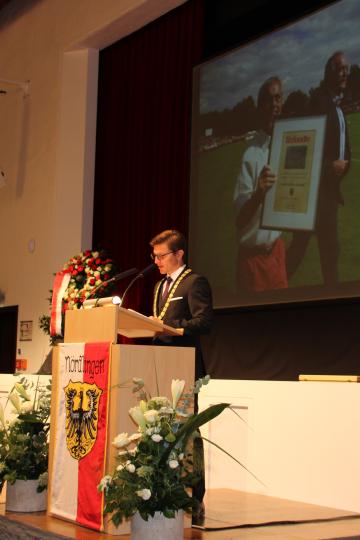 David Wittner an Nördlingen-Redpult, dahinter Foto von Alt-OB Hermann Faul und Gerd Müller 