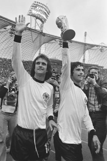 Gerd Müller mit dem WM-Pokal 1974. Links: Wolfgang Overath.