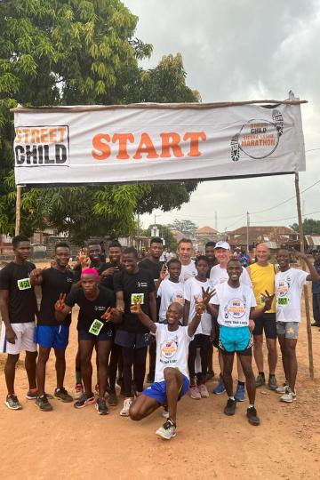 Ein Gruppenfoto mit anderen Läufern vor der Startlinie des Sierra Leone Marathons.