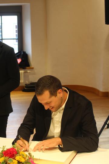 Christian Bold trägt sich ins Goldene Buch der Stadt ein.