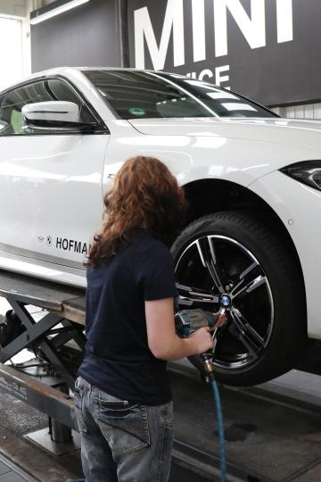 Auszubildende wechselt Reifen