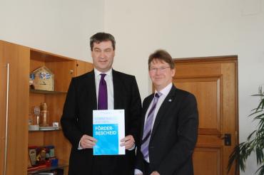 Markus Söder übergibt einen Förderbescheid in Höhe von 2,1 Millionen Euro an den Landrat Stefan Rößle. (Bild: Mara Kutzner)