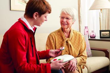Hausnotruf-Kundenberaterin erklärt das Gerät