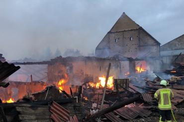 Die Feuerwehr kämpft noch immer gegen die Flammen in dem völlig zerstörten Hof. 