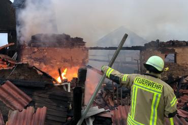 Feuerwehrleute kämpfen gegen den Brand in einem Landwirtschaftlichen Anwesen.