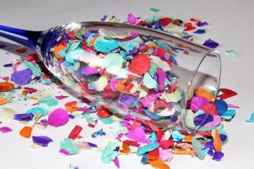 Das Bild zeigt ein Sektglas mit Konfetti. 