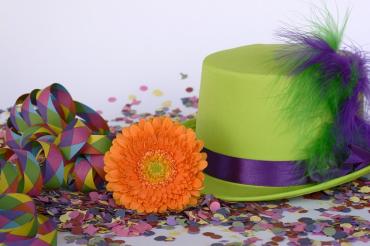 Das Bild zeigt Konfetti und einen grünen Hut. 