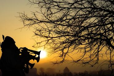 Das Bild zeigt Musiker vor einem Sonnenuntergang. 