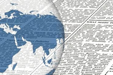 Das Bild zeigt eine Weltkugel und einen Zeitungsartikel. 