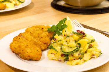 Das Bild zeigt ein Schnitzel mit Kartoffelsalat. 