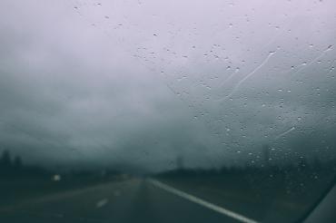 Das Bild zeigt eine nasse Fahrbahn. 