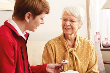 Hausnotruf-Kundenberaterin erklärt das Gerät