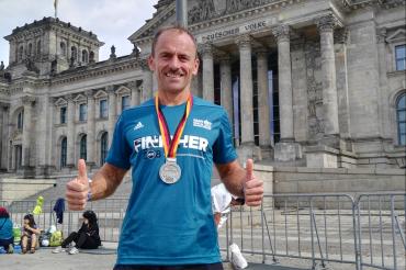 Auf diesem Bild sieht man Karlheinz Kurtz mit einer Medaille beim Berlin Marathon.