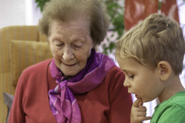 Das Bild zeigt eine Seniorin beim Vorlesen. 