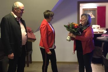 Das Bild zeigt Brigitte Kundinger-Schmidt und Peter Moll bei der Überreichung eines Blumenstraußes an Frau Friederike Rieger.