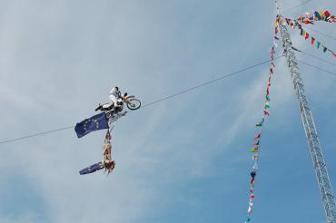 Falko Traber balanciert mit einem Motorrad über ein Hochseil. 