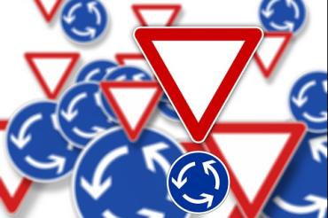 Das Bild zeigt Vorfahrts- und Kreisverkehrsschilder.