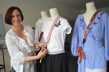 Das Bild zeigt Christine Moll. Sie dekoriert ihre Mode an Schaufensterpuppen. 