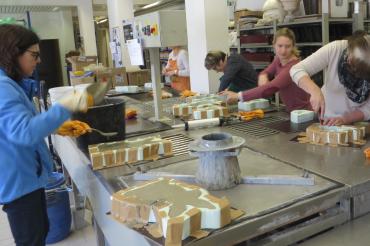 Das Bild zeigt Doris Thürheimer, Leiterin Bildungswerk (l.), mit vollem Eifer beim Erstellen eines Beton-Osterhasen.