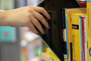 Das Bild zeigt ein Bücherregal mit einem Ipad. 