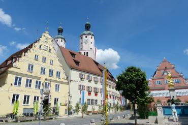 Das Bild zeigt den Wemdinger Marktplatz, das historische Rathaus und die Türme von St. Emmeram. 