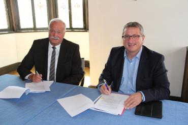 Das Bild zeigt Oberbürgermeister Hermann Faul und Jochen Schmid bei der Unterzeichnung des Netzbetriebsvertrages.