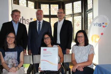 Das Bild zeigt das Team der Rieser Volkshochschule Nördlingen (v. li. Simone Heinze, Bianca Hahn, Heidi Hertle) mit Oberbürgermeister und 1. Vorsitzenden Hermann Faul, 2. Vorsitzenden Raimond Eberle und VHS-Leiter Peter Schiele mit dem EFQM-Zertifikat.