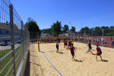 Schüler spielen auf einem Feld Volleyball. 