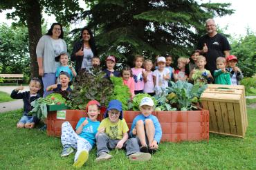 Kita-Leiterin Veronika Stoller (hinten links), Elvine Willmann (hinten, 2. von links) und Walter Willmann freuen sich mit Kindern der Kita Naseweis über die reiche Ernte.
