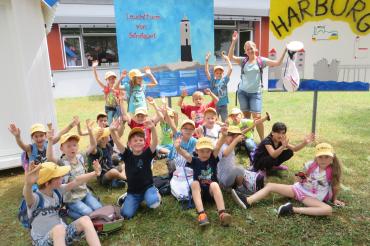 Klasse 1b nach ihrem Ausflug auf die Harburg vor ihrem Kunstwerk über den Leuchtturm von Sénéquet.