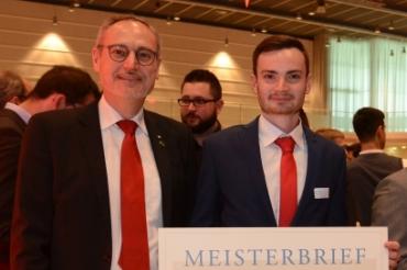 Thomas  Strobl übergibt seinem Sohn Anselm den Meisterbrief.