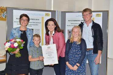 Landwirtschaftsministerin Michaela Kaniber (Mitte) übergibt den Tierwohl-Preis an Simone und Roland Naß und deren Kinder Amelie und Johannes