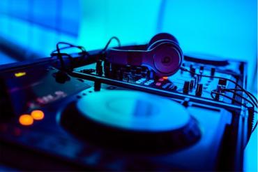 Das Bild zeigt die Schallplatten und Kopfhörer eines DJs