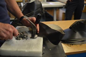 In Handarbeit werden die Ösen für die Schnürsenkel ins Leder gestanzt. 