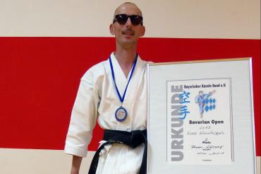 Das Bild zeigt Rene Steinhübel mit einer Urkunde