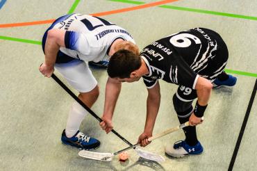 Das Bild zeigt zwei gegnerische Mannschaften beim Floorball