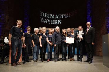 Auf dem Bild zu sehen: Geoparkführer Ernst Hopf, Cindy Cooper, Eva Wenninger, Elke Kugler, Heidi Greiner, Sonja Fall, Christine Hornung, Günther Zwerger (ehem. Geschäftsführer Geopark Ries e. V.), Heike Burkhardt (Geschäftsführerin Geopark Ries e. V.), Geoparkführer Kurt Kröpelin, Carolin Schober-Mittring, Landrat Stefan Rößle, Staatsminister der Finanzen und für Heimat Albert Füracker. 