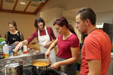 Das Bild zeigt Menschen, die miteinander kochen.