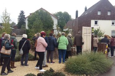 Mehrere Personen sehen sich einen Kleingarten an