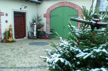 Ein schneebedeckter Nadelbaum in einem Hof