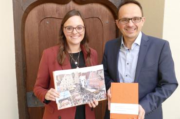 Bürgermeister Dr. Martin Drexler und Tourismusleiterin Judith Strohhofer freuen sich über das tolle Werk als Erinnerung an das Fest.