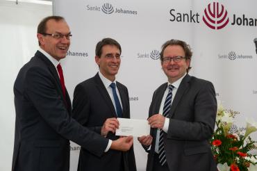 Für die neugeschaffenen Angebote überreichten Sparkassendirektor Johann Natzer (links) und Oberbürgermeister Armin Neudert (rechts) eine Spende der Sparkasse Donauwörth in Höhe von 1.000 Euro an den Direktor der Stiftung Sankt Johannes, Robert Freiberger.